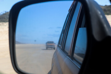 Reflection on a side mirror of a car behind