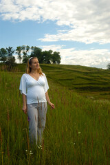 Beautiful pregnant woman relaxing outside in the park