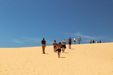Group of friends walking up a sand dune 2