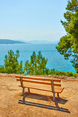 Naklejka na ściany i meble Public park with bench on the coast of the sea