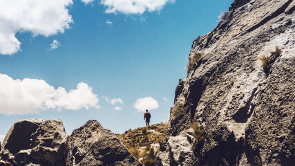Viajero haciendo trekking en una montaña y cielo azul