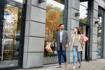 Adult woman and man with shopping bags