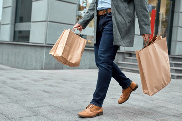 Adult man walking at street with shopping bags