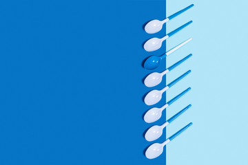 Abstract blue background with white plastic spoons.