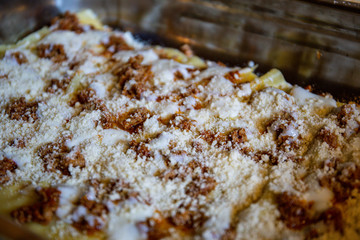 The making of the traditional italian lasagna: layers of paste, italian "ragù" sauce, bechamel and parmesan cheese. Delicous italian recipe.