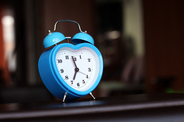 Blue alarm clock in the form of a heart in the interior