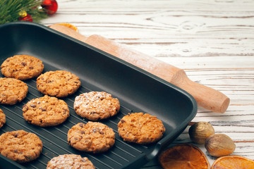 Top view of oat cookies in baking tray on wooden table