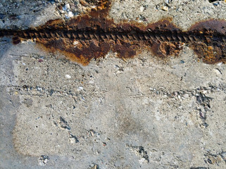 Concrete with a piece of rusty metal reinforcement.