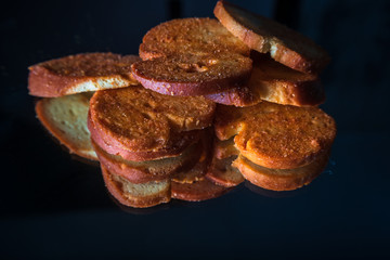 Mini bruschettes with spices with reflection on shiny black background