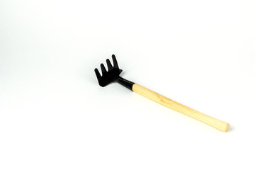 Little rake, wooden handle, decorative tools. Isolated on white background. Close up shot.