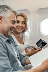 Obraz premium Happy pretty woman is holding perfume in cabin