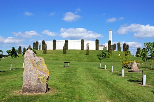 View of the Armed Forces Memorial with a large rock in the foreground, National Memorial Arboretum, Alrewas, UK.