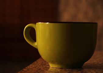 Big green cup standing on table in morning light