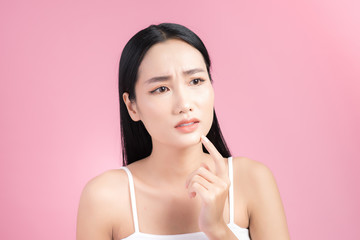 Young Asian woman touch and worry about her face. Acne, pimple, clear and clean, oily, dry skin...