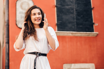 Beautiful woman traveler  using phone walking on the old town street.