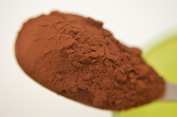 cacao  su un cucchiaino di metallo fotografia macro