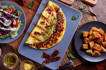Beacon omelette with Cheese in blue plate on wood table