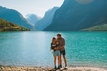 Family vacation couple traveling with baby outdoor healthy lifestyle activity mother and father parents with child adventure trip in Norway Lovatnet lake