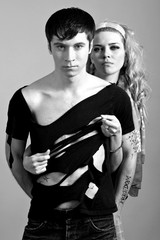 Young woman in pink clothing embracing young man in black