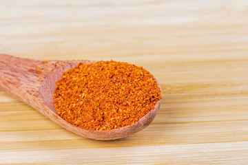 Paprika spices, a sweet peper on a wooden background