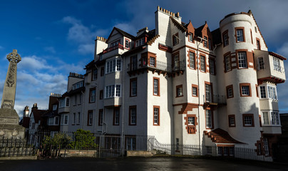 War memorial and large white house by Edinburgh Castle. People in front of a war memorial and large white house at the head of the Royal Mile, near the entrance