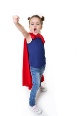 Adorable little girl flying like a superhero in blue t-shirt and red mantle. Super girl. The new generation saves the world. Good triumphs over evil. Funny kid portrait