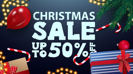 Christmas sale, up to 50% off, blue greeting card with presents, red balloon, candy cans, garland and Christmas tree branches, top view