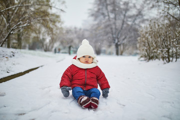 Happy smiling baby girl sitting in snow