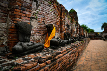 Ruined Buddha statue and ancient building at Wat Mahathat, “the temple of the Great Relic” one...