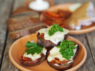 brown bread sandwiches with sun-dried tomatoes on a rustic wooden tableOLYMPUS DIGITAL CAMERA