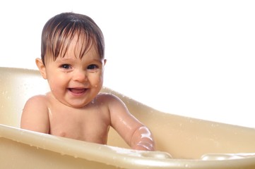 Fototapeta na wymiar Happy baby girl under splashes of water in bath