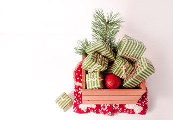 Christmas background with gift boxes and pine branch on a white wooden background.