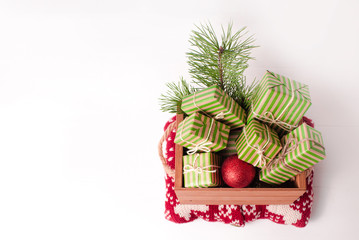 Christmas background with gift boxes and pine branch on a white wooden background.