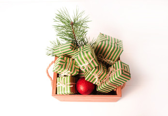Christmas background with gift boxes and pine branch on a white wooden background.