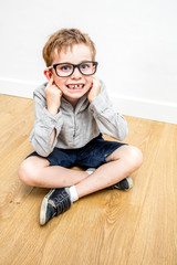 happy boy with nerd eyeglasses covering ears for self-respect