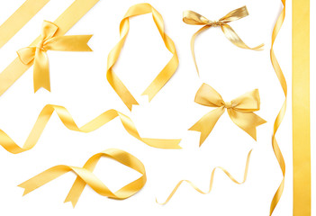 Golden ribbons and beautiful bows on white background