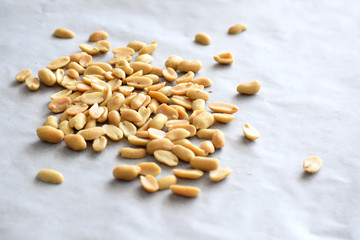 Salted peanuts on a parchment paper with copy space on the right side. 