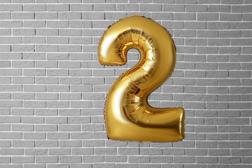 Balloon in shape of figure 2 on brick background