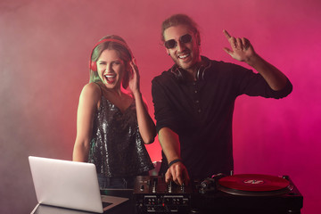 Young djs playing music in nightclub