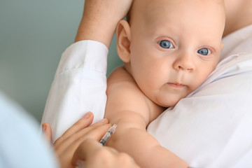 Nurse vaccinating little baby in clinic, closeup