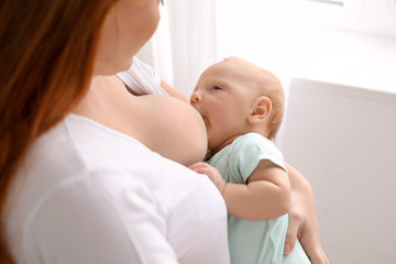 Obraz na płótnie Canvas Young woman breastfeeding her baby at home