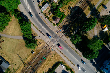 Aerial view over busy city roads with cars and railroads, summer day in city 