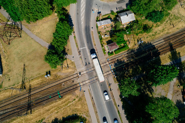 Aerial view over busy city roads with cars and railroads, summer day in city 