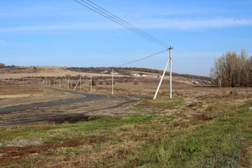 Beautiful autumn landscape with hills, road and electric posts.