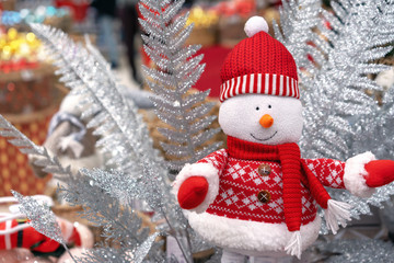 Cristmas soft toy of a snowman in a red sweater, scarf and hat.