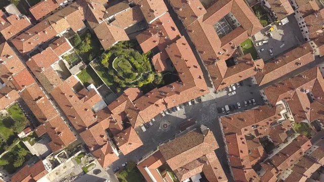 Top down aerial view of a small historic town Venzone in Northern Italy with red tiled roofs of old buildings.