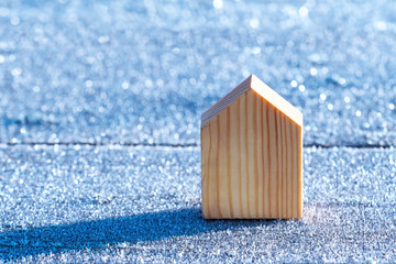 Wooden house stands on a snow and ice covered surface. Winter. Concept of ecological housing, ecology