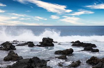 Ocean and rocks with blue sky during daytime