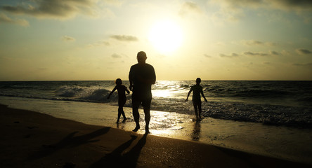 Fototapeta premium Father with two kids enjoying summer vacation on the beach