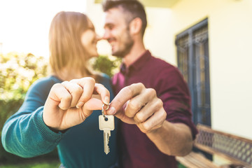 Young couple showing up new house key.